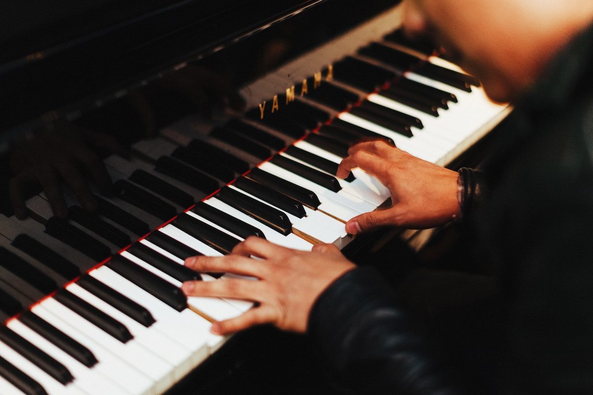 close up of mans hands playing the piano