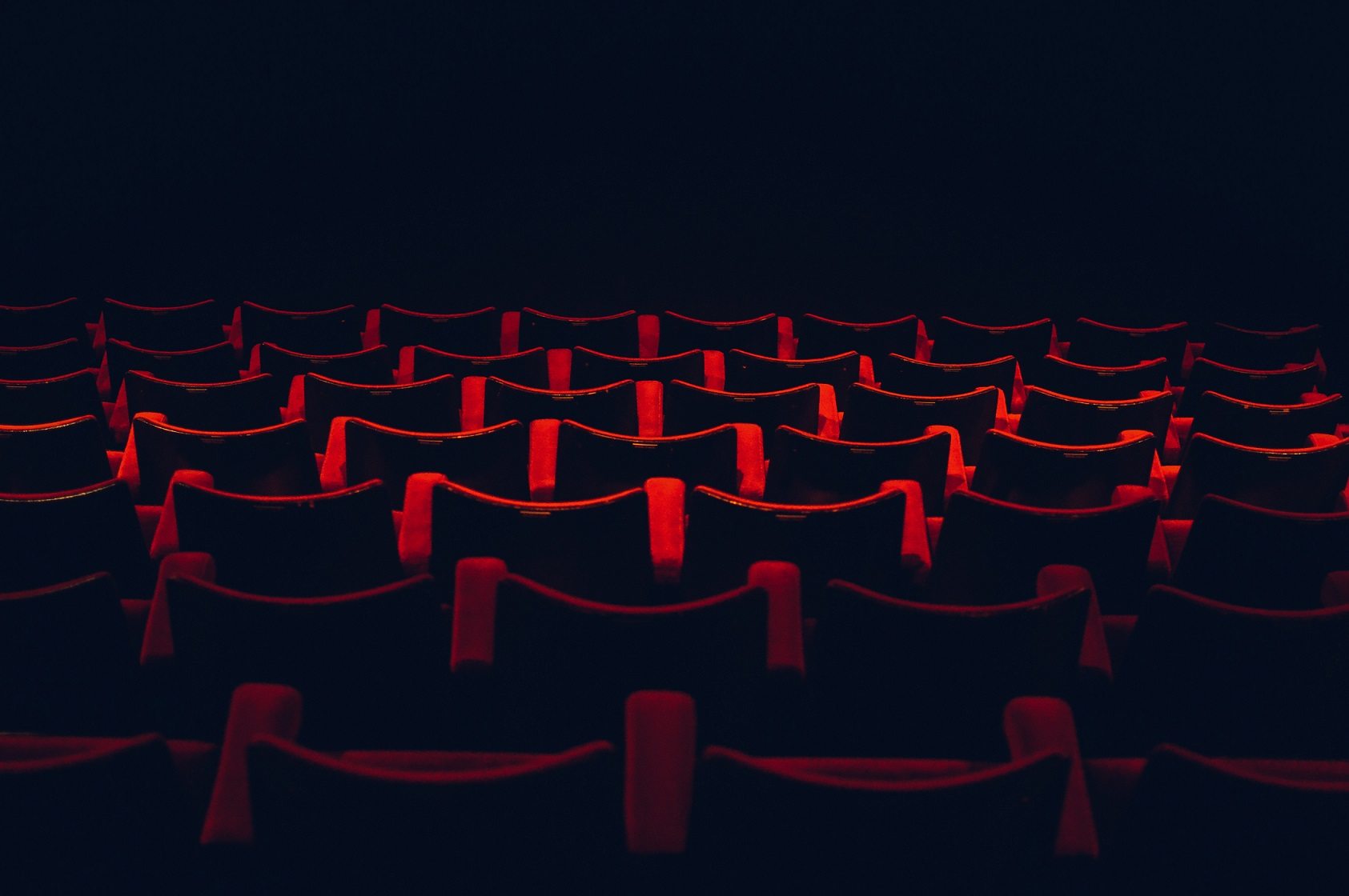 rows of empty red seats in a theater