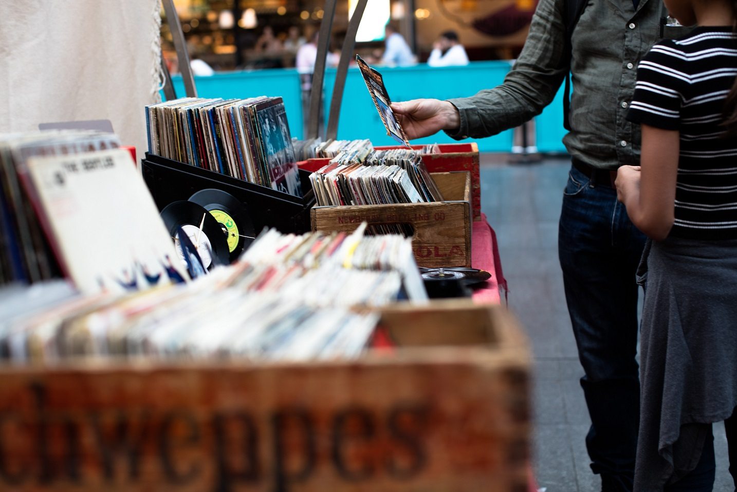 close up of shoppers looking through old record boxes