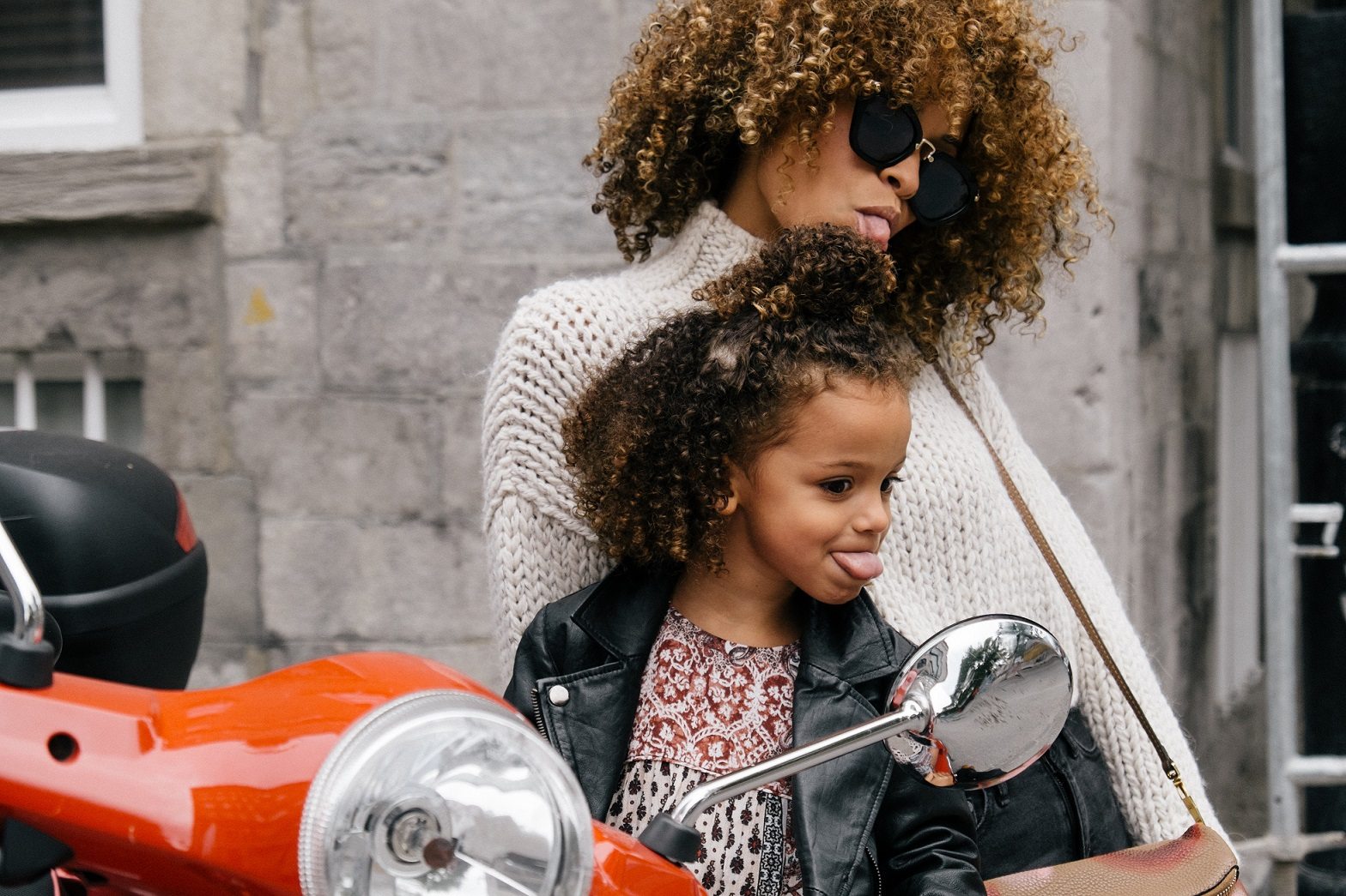 mother and daughter acting silly sticking out tongues in mirror