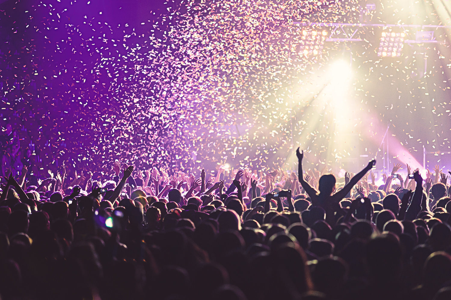 crowd at a concert with confetti falling from the ceiling