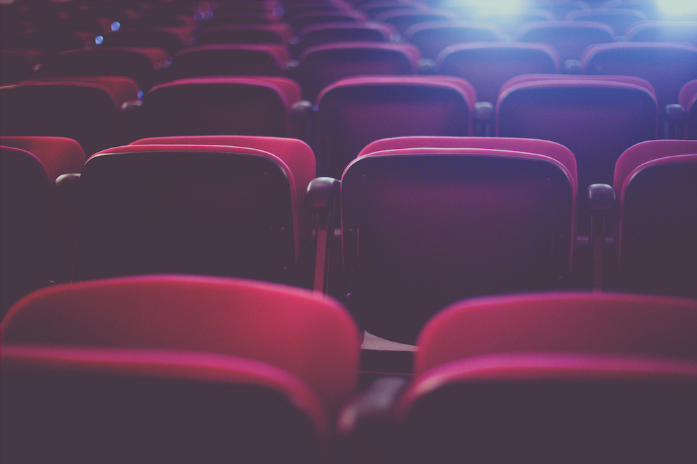 Rows of red seats in a cinema theater.